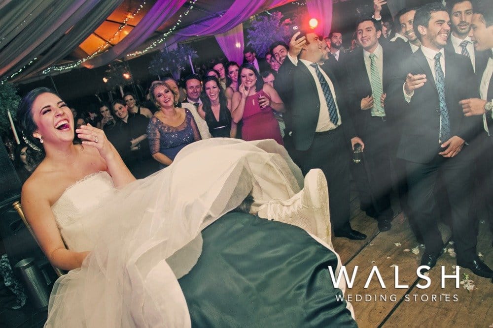 fotos de boda en hacienda nueva- novio sacando liga a novia en fiesta