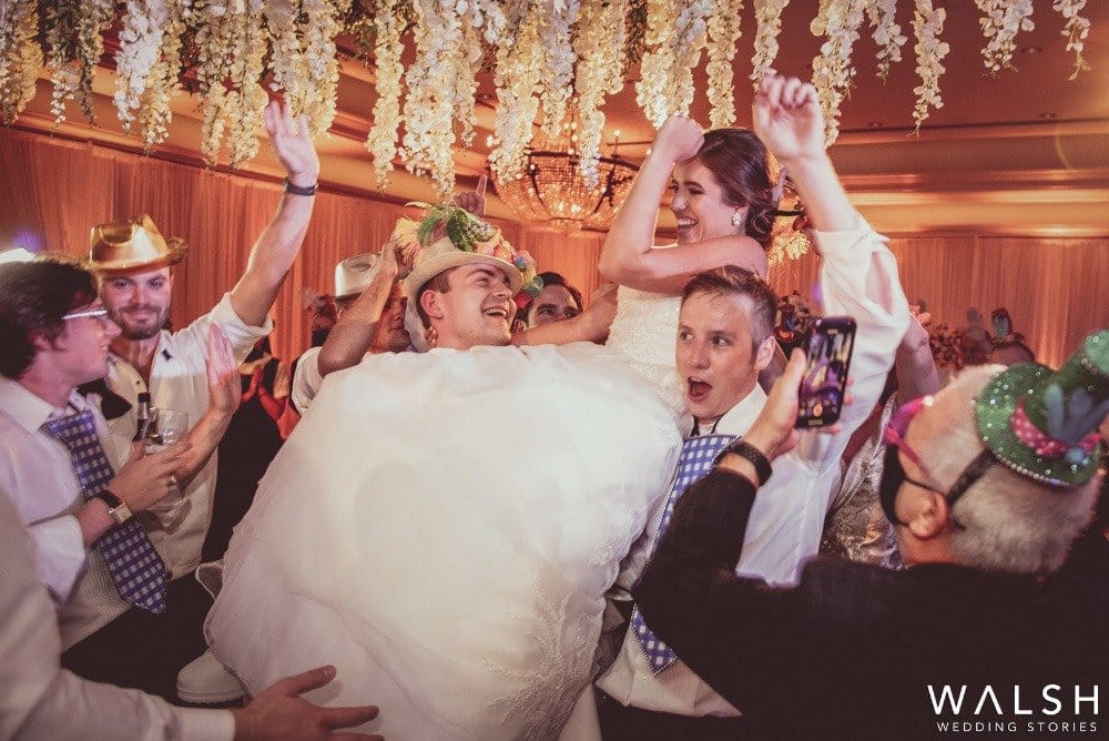 bride carried by guests at wedding